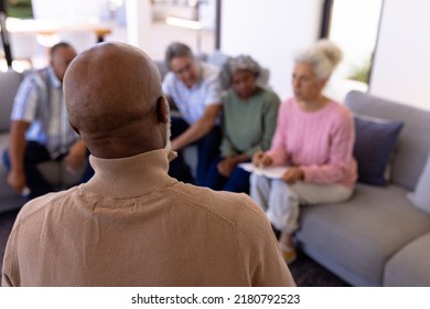 African american senior man sharing his emotions with multiracial friends in retirement home. Rear view, sadness, unaltered, group therapy, mental health, stress, together, support, assisted living. - Powered by Shutterstock