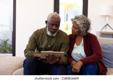 African american senior man using digital tablet while sitting with woman on sofa in nursing home. Friendship, wireless technology, unaltered, togetherness, support, assisted living, retirement. - Powered by Shutterstock