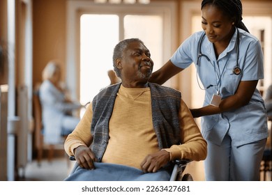 African American senior in wheelchair talking to a nurse at residential care home. - Shutterstock ID 2263427681