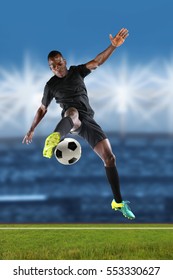 African American Soccer Player Kicking Ball Inside Stadium