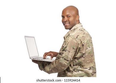 African American Soldier Looks Over His Shoulder While Typing On A Computer