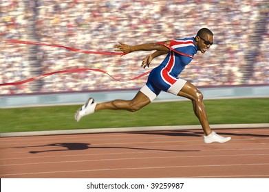 African American sprinter crossing the finish line and breaking the tap. Horizontally framed shot. - Shutterstock ID 39259987