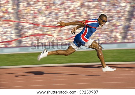African American sprinter crossing the finish line and breaking the tap. Horizontally framed shot.