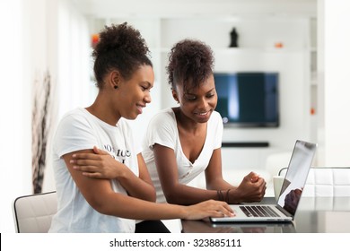 African American student girls using a laptop computer - black people