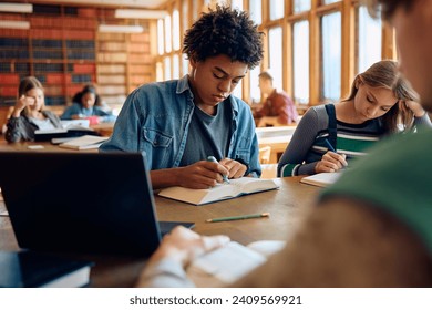 African American student and his friends studying at high school library,  - Powered by Shutterstock