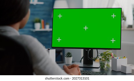 African American Student Looking At Mock Up Green Screen Chroma Key Display Listening University Professor During Online Videocall Meeting Conference. Black Woman Working Remote From Home