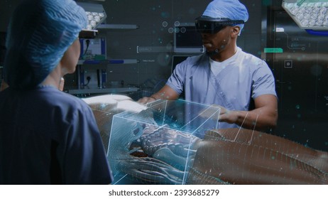 African American surgeon and nurse in AR headsets work in surgery room using holographic display. 3D graphics of virtual human skeleton and organs. AI technologies in medicine. Futuristic healthcare. - Powered by Shutterstock