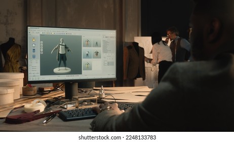 African American tailor or fashion designer creates clothes and develops future wear collection in 3D modeling program. He works in luxury workshop or tailoring studio on laptop. Fashion concept. - Powered by Shutterstock