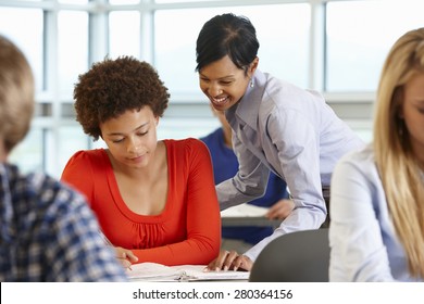 African American Teacher Helping Student In Class