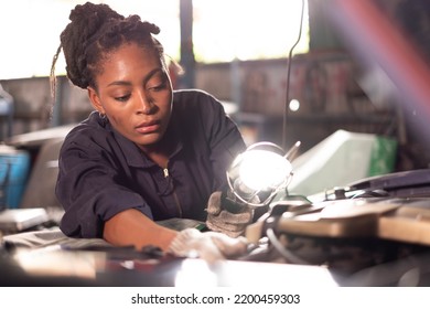 African american technician female Mechanic working under the hood at the repair garage. - Powered by Shutterstock