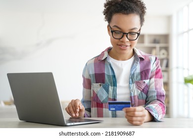 African American Teen Girl Holds Credit Bank Card Shopping Online On Laptop. Young Biracial Female Buy Pay On Internet On Computer At Home, Browsing Banking Services, Checking Cashback Bonus.