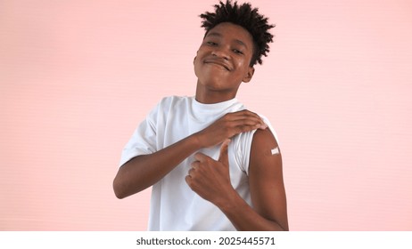 African American teenager showing COVID-19 vaccine bandage merrily in concept of coronavirus vaccination program to vaccinate citizen . - Powered by Shutterstock