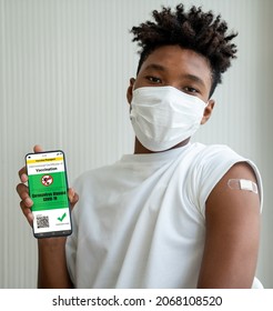 African American teenager shows vaccine passport on mobile phone to validate travel permission by the digital document