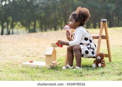 African American Toddler Little Girl Playing Toy In The Park. Children With Curly Hair Having Fun Outdoor. Black Kid People Enjoying Outside