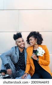 African American Transgender Couple Sitting And Smiling With Simple Background