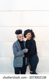 African American Transgender Couple Smiling, Laughing, Hanging Out In Front Of Blank Wall With Copy Space