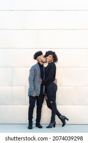 African American Transgender Couple Smiling, Laughing, Hanging Out In Front Of Blank Wall With Copy Space