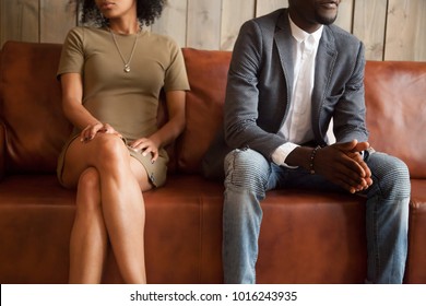 African american unhappy couple sitting on couch after quarrel fight thinking of break up or divorce, black upset man and woman not talking having conflict, bad relationships concept, close up view