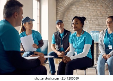 African American volunteer and her coworkers talking while organizing donations at community center.  - Shutterstock ID 2147205089