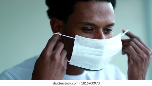 African american wearing and adjusting mask against coronavirus - Powered by Shutterstock