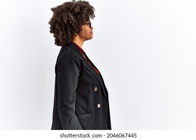 African american woman with afro hair wearing business jacket and glasses looking to side, relax profile pose with natural face and confident smile. 