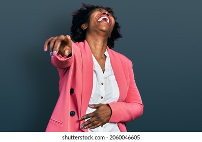 African american woman with afro hair wearing business jacket laughing at you, pointing finger to the camera with hand over body, shame expression 
