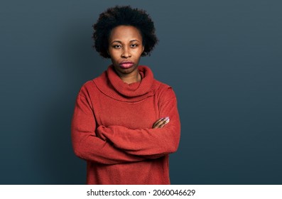 African american woman with afro hair wearing turtleneck sweater skeptic and nervous, disapproving expression on face with crossed arms. negative person. 