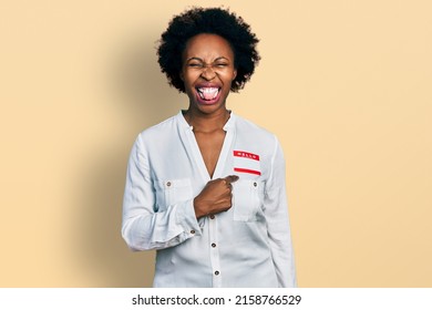 African American Woman With Afro Hair Wearing Hello My Name Is Sticker Identification Sticking Tongue Out Happy With Funny Expression. 