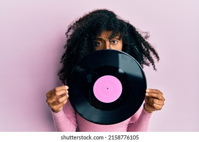 African American Woman With Afro Hair Holding Vinyl Disc Depressed And Worry For Distress, Crying Angry And Afraid. Sad Expression. 