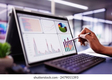 African American woman analyzing financial data on laptop screen in hybrid office setting for digital entrepreneurship KPI dashboard. - Powered by Shutterstock