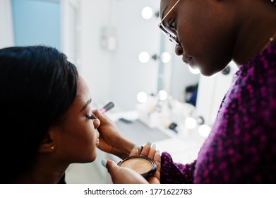 African American Woman Applying Make-up By Make-up Artist At Beauty Saloon.