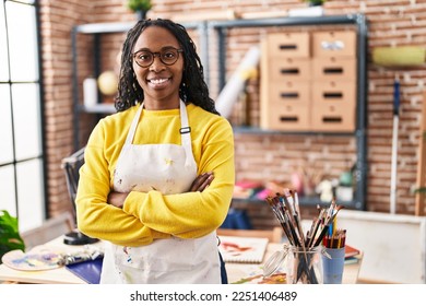 African american woman artist smiling confident standing with arms crossed gesture at art studio - Powered by Shutterstock