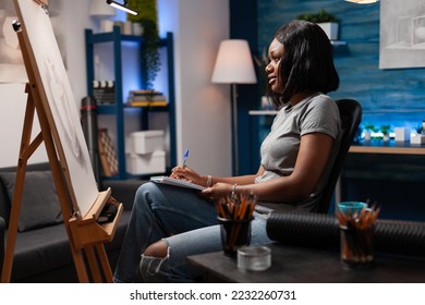 African american woman and artistic abilities appreciating completed pencil drawing in modern art studio  Female professional artist revising artwork to give final details sitting in work room 