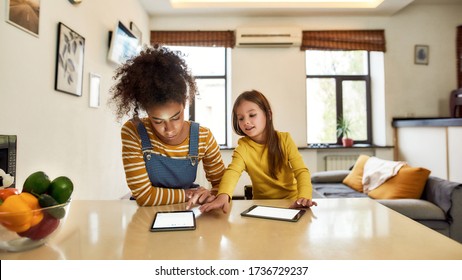 African American Woman Baby Sitter And Caucasian Little Girl Reading, Using Tablet Pc. Kid Reaching Nannys Touch Pad. Children Education, Leisure Activities, Babysitting Concept. Web Banner