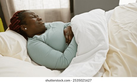 African american woman with braids experiencing discomfort in a clinic bed, portraying pain or illness in a healthcare setting. - Powered by Shutterstock