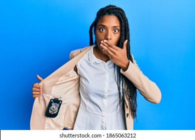 African American Woman With Braids Showing Detective Badge Covering Mouth With Hand, Shocked And Afraid For Mistake. Surprised Expression 