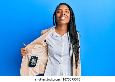 African American Woman With Braids Showing Detective Badge Looking Positive And Happy Standing And Smiling With A Confident Smile Showing Teeth 