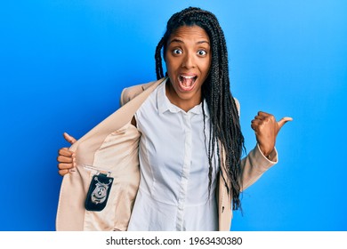 African American Woman With Braids Showing Detective Badge Pointing Thumb Up To The Side Smiling Happy With Open Mouth 