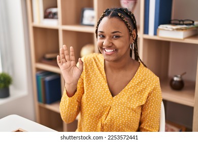 African american woman with braids sitting at dinning room looking positive and happy standing and smiling with a confident smile showing teeth  - Shutterstock ID 2253572441