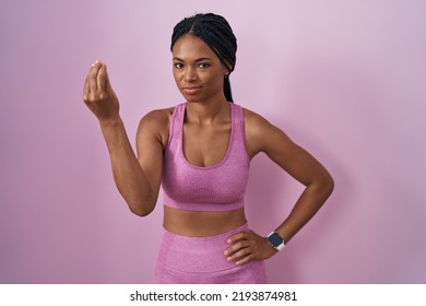 African American Woman With Braids Wearing Sportswear Over Pink Background Doing Italian Gesture With Hand And Fingers Confident Expression 