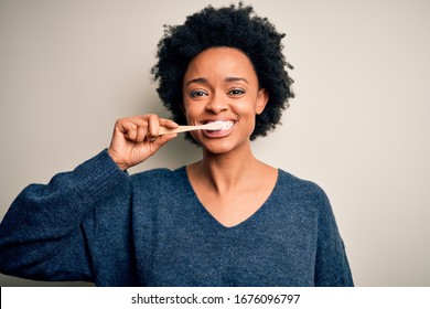 African american woman brushing her teeth using tooth brush and oral paste, cleaning teeth and tongue as healthy health care morning routine