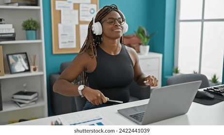 African american woman business worker listening to music doing drummer gesture at the office - Powered by Shutterstock