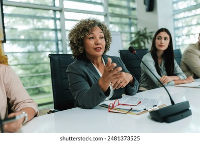 African American woman CEO talking on the microphone on meeting with her colleagues about business plan, future collaboration. - Powered by Shutterstock