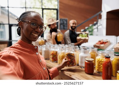 African american woman compliments an undiscovered eco-friendly local supermarket in her vlog, showcasing excellent organic products. Female influencer presenting a new sustainable bio store. - Powered by Shutterstock