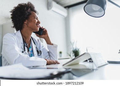 African American Woman Doctor Working At Her Office Online Using Portable Inormation Device. Telemedicine Services. Primary Care Consultations, Psychotherapy, Emergency Services. 