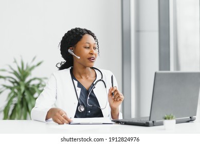 African American Woman Doctor Working At Her Office Online Using Portable Inormation Device. Telemedicine Services. Primary Care Consultations, Psychotherapy, Emergency Services.