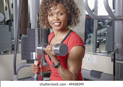 African American Woman Doing Bicep Curls In A Gym