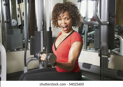 African American Woman Doing Bicep Curls In A Gym