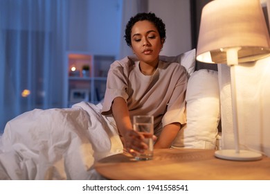 African American Woman Drinking Water At Night