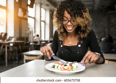 african american woman eating - Powered by Shutterstock